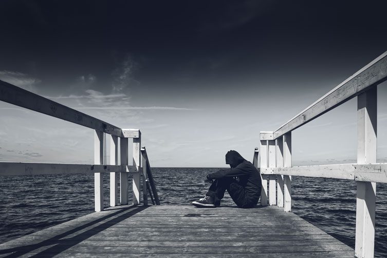 Slippery slopes - man sitting on pier - black and white pier - great oaks recovery - houston drug rehab center - texas alcohol addiction treatment