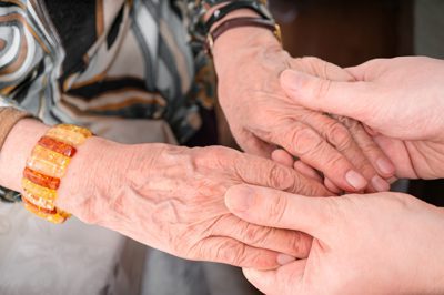 Treating Seniors for Addiction - man holding elderly woman's hands