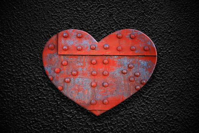 Are You Helping or Enabling - metal armored heart on black background