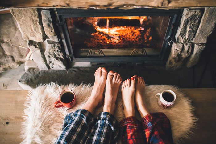 Tips-for-Staying-Sober-Over-the-Holidays - feet in front of fireplace