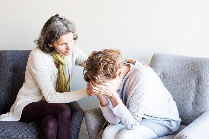 older woman consoling senior woman - interventionist