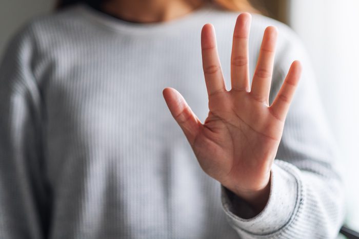 closeup of woman holding hand out in stop gesture or showing number five on her fingers - signs of drug and alcohol abuse