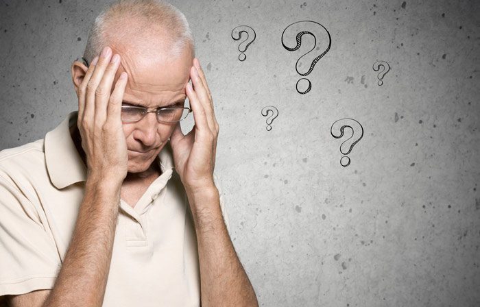 senior man with hands on his head looking confused on background with question marks - Alzheimer's and addiction